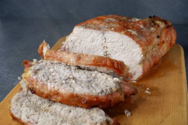 Ahşap bir tahtanın üzerinde büyük bir parça kızarmış et. Kızarmış domuz bifteği kızartma tavasında, yakın görüş. Izgara fileto..