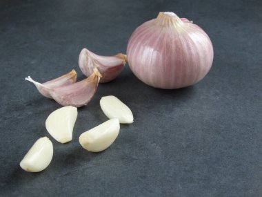 onion and garlic on grey stone table. Raw Vegetables on a Dark Background