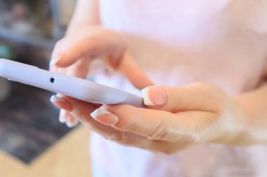Hands using a Smartphone. Midsection Of Woman Using Mobile Phone At Home. Cropped anonymous female using mobile phone.