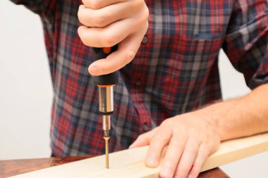 Handworker working with an electric screwdriver. A man using the drill in the home
