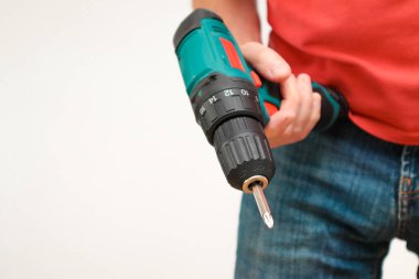 Hand holding cordless drill. Handyman with a tool screwdriwer drill. Electrician with drill. Worker standing with tool