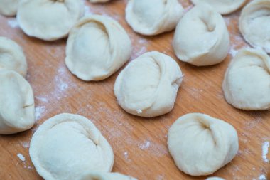 Dumplings with meat. The process of cooking Asian gyoza dumplings. Flour, dough on a wodden background. Home cooking dumplings, dough and minced meat