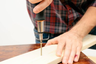 Handworker working with an electric screwdriver. A man using the drill in the home
