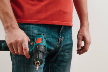 Hand holding cordless drill. Handyman with a tool screwdriwer drill. Electrician with drill. Worker standing with tool
