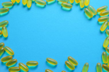 Balık yağı omega 3 jel ca psules mavi arka planda fotokopi alanı ile. Sağlık sigortası, vitaminler, günlük beslenme konsepti. Balık yağı, omega3, D vitamini, E vitamini.