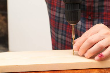 Handworker working with an electric screwdriver. A man using the drill in the home