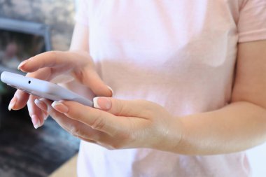 Hands using a Smartphone. Midsection Of Woman Using Mobile Phone At Home. Cropped anonymous female using mobile phone.