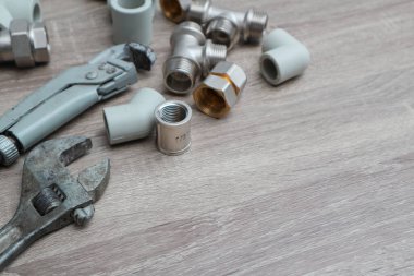 İş araçları arka planı. Boru aksesuarları konsept seti ahşap arka planda ayarlanabilir anahtarlar yerleştirir. Tesisat araçları ve ekipman kopyalama alanı olan tablo üzerinde