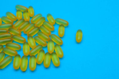 Balık yağı omega 3 jel ca psules mavi arka planda fotokopi alanı ile. Sağlık sigortası, vitaminler, günlük beslenme konsepti. Balık yağı, omega3, D vitamini, E vitamini.
