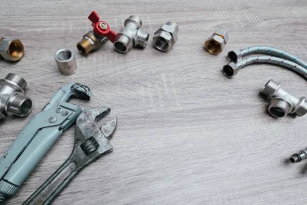 Work tools background. Plumbing concept set of piping accessories plumb adjustable wrenches fittings on wooden background. Plumbing tools and equipment on table with copy space