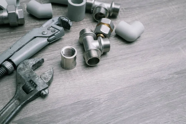 Work tools background. Plumbing concept set of piping accessories plumb adjustable wrenches fittings on wooden background. Plumbing tools and equipment on table with copy space