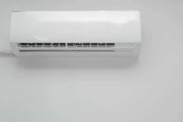 Air conditioner on white wall background. Split air conditioner on a white wall. Closeup image electric equipment in house.