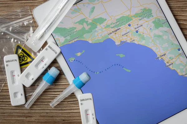 Covid test kitleri Los Angeles 'ın batı kıyısı haritasının yanında bir masanın üzerinde duruyordu.