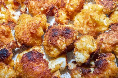 cauliflower fried in breadcrumbs on a plate top view close-up