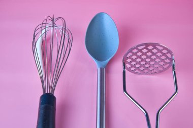 kitchen utensils on pink background top view