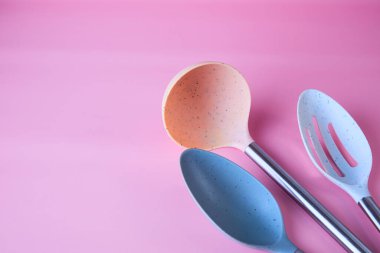 kitchen utensils on pink background top view