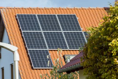 Mavi gökyüzü, yeşil çimen, elektrik ve enerjiye sahip modern bir bina manzarası,