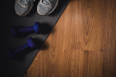 Spor ayakkabıları ve spor ayakkabıları için dambıllar. Jimnastik aksesuarları. Uzayı kopyala Seçici odak.