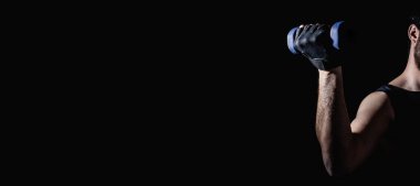 Genç adam dambıllarla kas ve güç egzersizleri yapıyor. Yüksek yoğunluklu fitness. Uzayı kopyala Seçici odak.