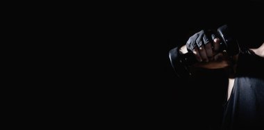 Genç adam dambıllarla kas ve güç egzersizleri yapıyor. Yüksek yoğunluklu fitness. Uzayı kopyala Seçici odak.