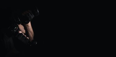 Genç adam dambıllarla kas ve güç egzersizleri yapıyor. Yüksek yoğunluklu fitness. Uzayı kopyala Seçici odak.