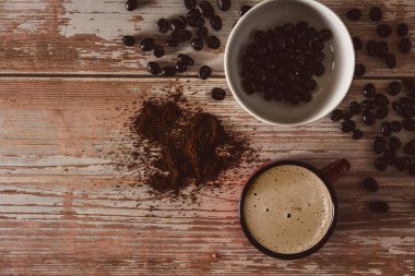 Kahveli kahve fincanı ve eski ahşap yüzeyde kahve çekirdeği. Uzayı kopyala Seçici odak.