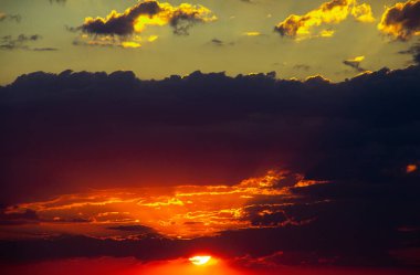 Colorful sunset on a cloudy day with big sun. Selective focus. Copy space. 