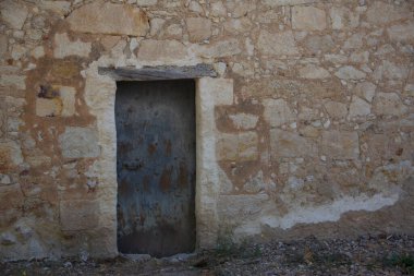 Old door integrated on stone wall. Selective focus. Copy space.