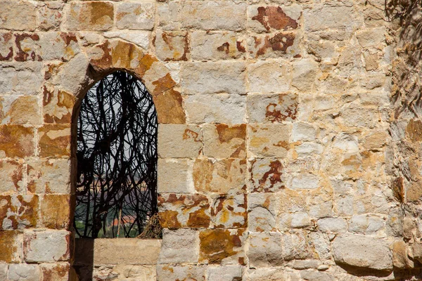 Detail of old castle window on stone wall. Copy space. Selective focus.