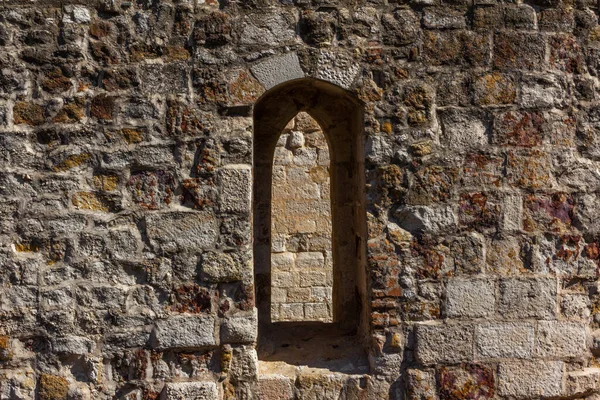 Detail of old castle window on stone wall. Copy space. Selective focus.