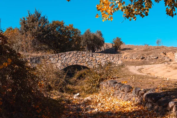 Stone bridge in a park on an autumn day. Selective focus.