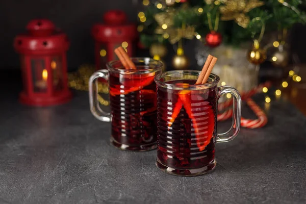 Hot mulled red wine in two glass cups for winter and Christmas with orange, apple and various spices. Preparing for the Christmas holidays — Stock Photo, Image