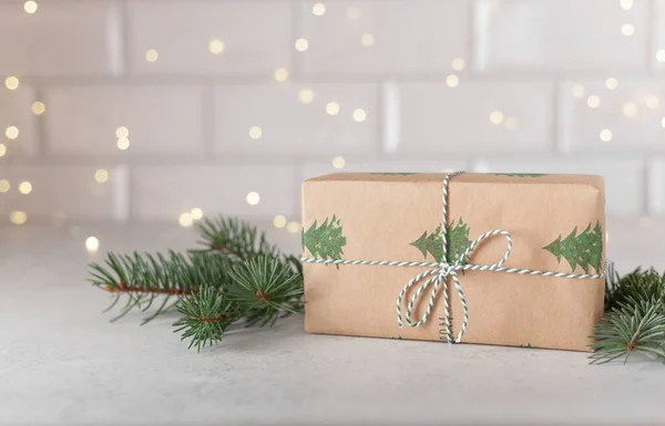 圣诞礼物简约主义，以冷杉枝条包裹灰色背景，配以带有复制空间的花环灯，寒假概念 免版税图库图片
