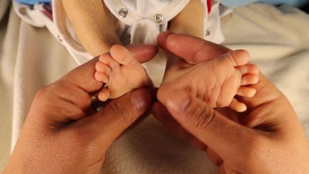 家族の愛と信頼の象徴として 新生児の足を握っている父 子供を持つ親の瞬間 幸せな家族の医療と医療機関の一部父の日の概念 — ストック動画