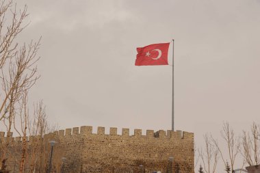 Erzurum, Erzurum 'da Erzurum Şatosu (Türkçe: Erzurum Kalesi) üzerinde rüzgarda dalgalanan 02.25.2022 Türk bayrağı. Türkiye Erzurum seferi, kar yağışı. Antik İslami bina. Vatanseverlik. Sıcaklık -50 C