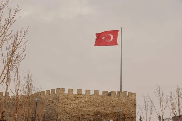 Erzurum, Erzurum 'da Erzurum Şatosu (Türkçe: Erzurum Kalesi) üzerinde rüzgarda dalgalanan 02.25.2022 Türk bayrağı. Türkiye Erzurum seferi, kar yağışı. Antik İslami bina. Vatanseverlik. Sıcaklık -50 C