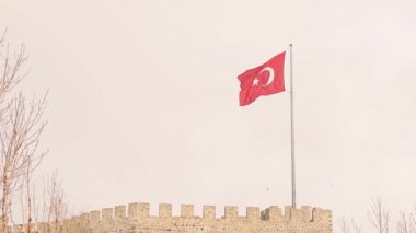 Erzurum, Erzurum 'da Erzurum Şatosu (Türkçe: Erzurum Kalesi) üzerinde rüzgarda dalgalanan Türk bayrağı 02.25.2022. Erzurum seferi, kar yağışı. İslami antik bina. Vatanseverlik. Sıcaklık -50 C
