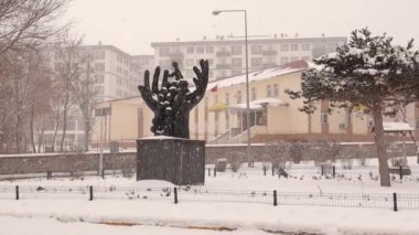 Türkiye 'de kar fırtınası sırasında Erzurum. El heykeline kar yağıyor. Kışın soğuk hava, kar fırtınası. Eski binaya kar yağışı. Türkiye 'ye git. Dondur, dondur, dondur.