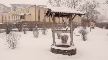 Türkiye 'de kar fırtınası sırasında Erzurum. Eski bir su kuyusuna kar yağıyor. Kışın soğuk hava, kar fırtınası. Eski binaya kar yağışı. Türkiye 'ye seyahat. Dondur, dondur, dondur.