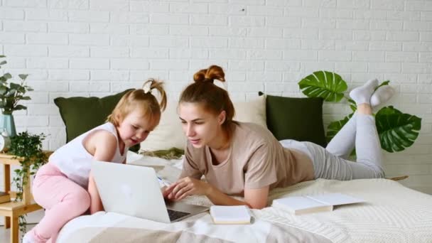 Anya otthonról dolgozik, munkahelyi videohívása van, miközben gyermeke eltereli és felhívja magára a figyelmet. Távoli munka. Távközlési munka — Stock videók