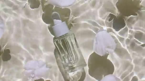 Стеклянная парфюмерная бутылка, косметика ароматического эфирного масла. Вид сверху медленное движение волн воды. Чистая вода с отражениями, преломлением солнечного света и теней. Природная косметика и уход за кожей. — стоковое видео