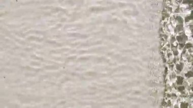 Dalgaların Dalgalandığı Güzel Pastel Su Yüzeyi. Yansımalı berrak mavi su, kırılma güneş ışığı. Su yüzeyi dokusu üst görünümü.