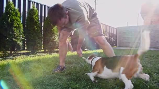 Mężczyzna bawi się swoim psem na świeżym powietrzu i traktuje jej zwierzaka smakołykiem. Drażni szczeniaka ulubioną zabawką. Zwolniony ruch — Wideo stockowe