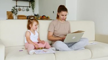 Anne evden çalışıyor, iş yerinden bir telefon görüşmesi yapıyor ve çocuğu yakınlarda oynuyor. Uzaktan kumanda. Telekom işi