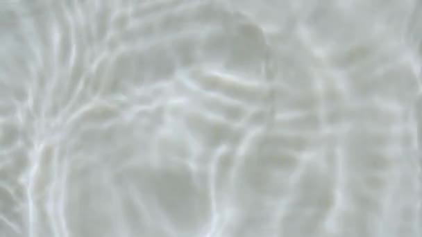 水花飞溅水滴造成裂口.阳光和阴影清澈的水,反射阳光,慢动作.水面纹理顶视图.清澈的游泳池荡漾着波浪.4k — 图库视频影像