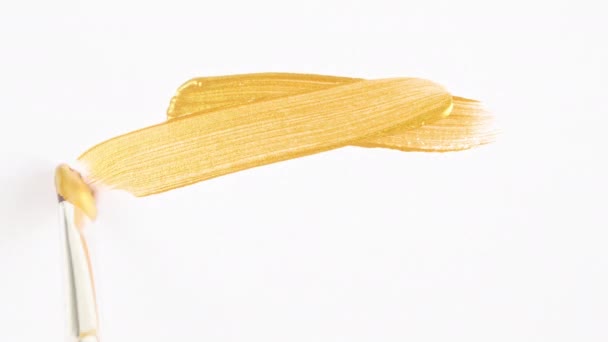 Pennellate astratte di pennello oro applicato isolato su uno sfondo bianco. Texture macchia di vernice dorata. Illustrazione artistica con texture scintillante dorata. Spalmi di cosmetici. — Video Stock