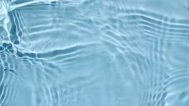 물 표면 텍스처 맨 위 뷰. 물은 파랑 색으로 튀긴다. 햇빛의 반사와 느린 움직임의 그림자를 가진 맑고 푸른 물이다. 운동은 깨끗 한 수 영장의 물결 과 물결을 일으킨다. 4k — 비디오