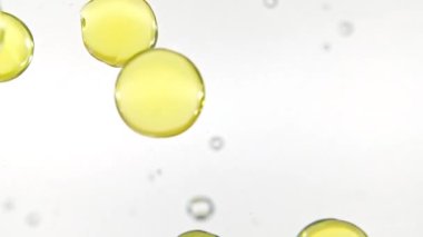 Kapsül hapları, Omega 3 altın yağ kapsülleri. Suya düşen hapların makro çekimi ve beyaz arka planda hava kabarcıkları. Tıp konsepti, sağlık, tedavi. Yavaş çekim.