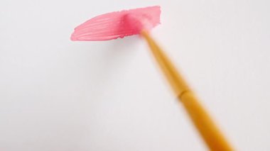 Beyaz arka planda izole edilmiş pembe boya fırçasının soyut fırça darbeleri. Pembe boya lekesi dokusu. Parlak desenli sanatsal illüstrasyon. Kozmetik kokuları.
