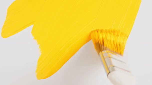 Abstrakcyjne pociągnięcia pędzlem żółtej szczotki malarskiej nałożone izolowane na białym tle. Żółta konsystencja farby. Żółty błyszczący teksturowana ilustracja artystyczna. Rozmazy kosmetyków. — Wideo stockowe
